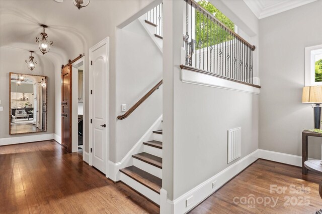 1501 Alydar Ct, Waxhaw, NC 28173 - stairs with a barn door, wood finished floors, baseboards, a chandelier, and ornamental molding