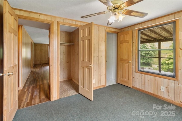 461 Tweed Rd, Madison, NC 28753 - unfurnished bedroom featuring wood walls, carpet, and ceiling fan