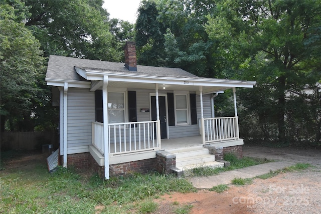 2017 Ashley Rd, Charlotte, NC 28208 - bungalow featuring covered porch, a chimney, and roof with shingles