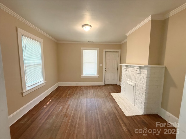 2017 Ashley Rd, Charlotte, NC 28208 - unfurnished living room featuring plenty of natural light, dark wood finished floors, ornamental molding, and a brick fireplace