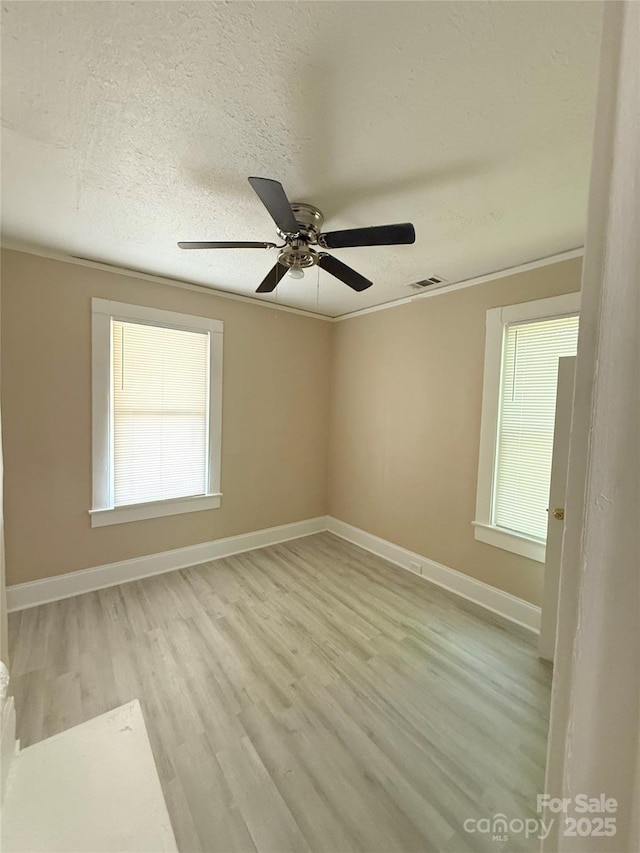 2017 Ashley Rd, Charlotte, NC 28208 - spare room featuring light wood-type flooring, ceiling fan, a textured ceiling, and crown molding