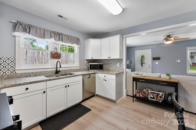 310 S Jacob St, Cherryville, NC 28021 - kitchen with stainless steel appliances, a sink, backsplash, white cabinetry, and light stone countertops
