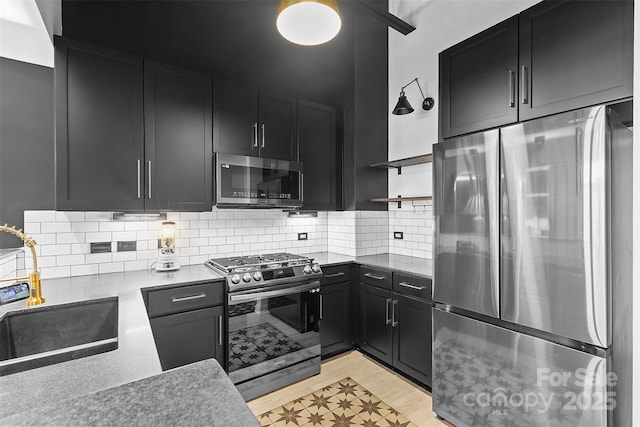 720 Governor Morrison St Unit 219, Charlotte, NC 28211 - kitchen featuring stainless steel appliances, dark cabinetry, open shelves, and light countertops