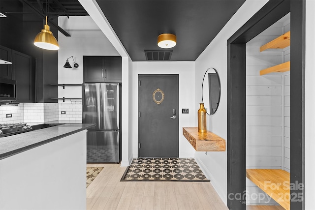 720 Governor Morrison St Unit 219, Charlotte, NC 28211 - kitchen with freestanding refrigerator, open shelves, dark cabinets, stovetop, and tasteful backsplash