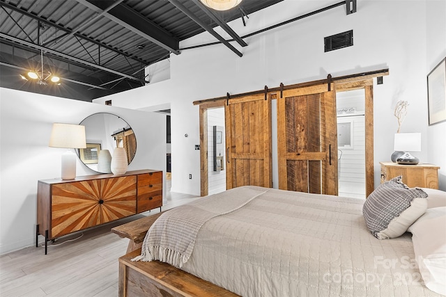 720 Governor Morrison St Unit 219, Charlotte, NC 28211 - bedroom featuring a high ceiling, a barn door, and wood finished floors