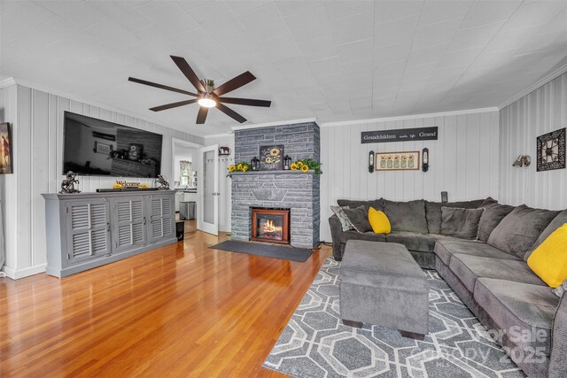 162 Candle St, West Jefferson, NC 28694 - living area with crown molding, a ceiling fan, wood finished floors, a fireplace, and wood walls