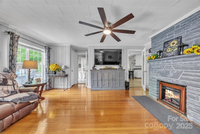 162 Candle St, West Jefferson, NC 28694 - living area featuring crown molding, ceiling fan, a stone fireplace, and wood finished floors
