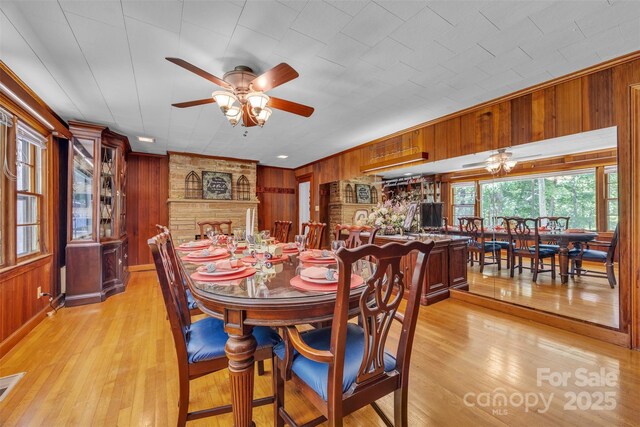 162 Candle St, West Jefferson, NC 28694 - dining room featuring wood walls, a ceiling fan, and light wood-style floors
