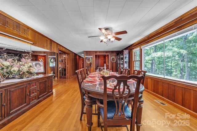 162 Candle St, West Jefferson, NC 28694 - dining room with wooden walls, light wood-type flooring, and a ceiling fan