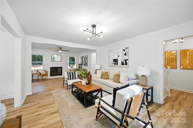 6127 Eagle Peak Dr, Charlotte, NC 28214 - living room featuring a chandelier, light wood-style floors, a fireplace, and ceiling fan
