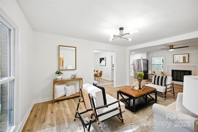 6127 Eagle Peak Dr, Charlotte, NC 28214 - living room with light wood finished floors, a chandelier, and a fireplace