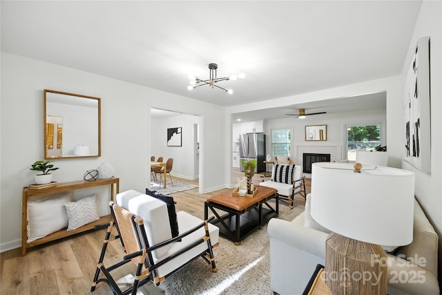 6127 Eagle Peak Dr, Charlotte, NC 28214 - living area featuring light wood-style flooring, a chandelier, and a brick fireplace