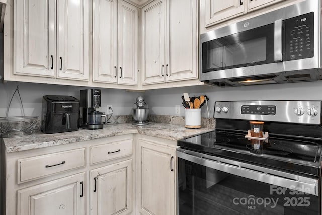 140 Maplewood Ct, Hudson, NC 28638 - kitchen featuring appliances with stainless steel finishes, light stone counters, and white cabinets