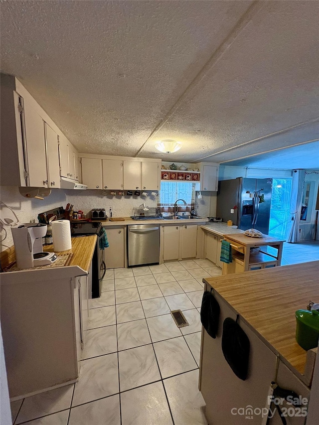5022 Wrenn Dr, Denver, NC 28037 - kitchen with stainless steel appliances, a sink, under cabinet range hood, a textured ceiling, and white cabinetry