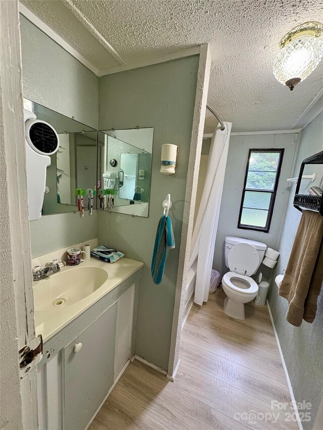 5022 Wrenn Dr, Denver, NC 28037 - bathroom featuring toilet, wood finished floors, a textured ceiling, vanity, and shower / tub combo with curtain