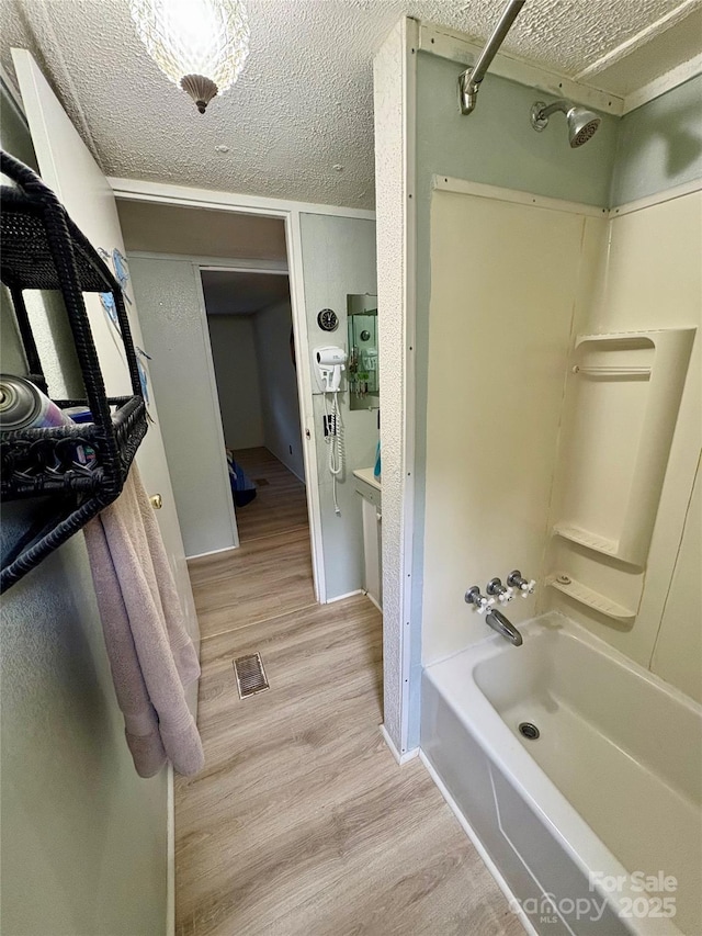 5022 Wrenn Dr, Denver, NC 28037 - full bath featuring tub / shower combination, wood finished floors, a textured ceiling, and baseboards