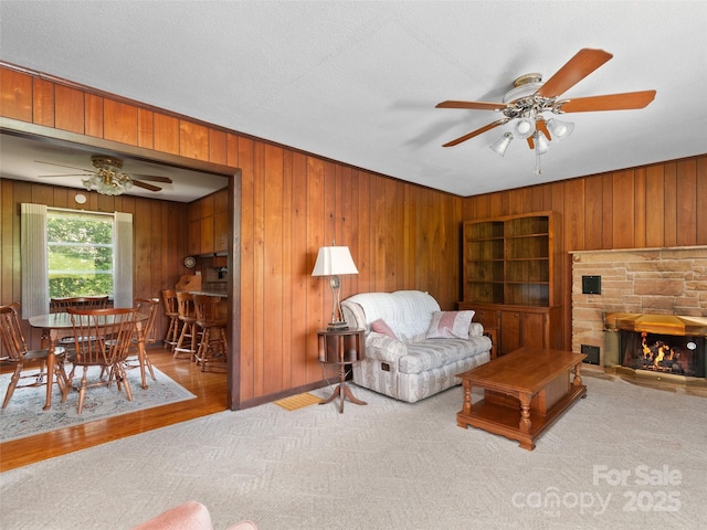 167 Panorama Dr, Franklin, NC 28734 - carpeted living room featuring a ceiling fan, wood walls, a fireplace, and wood finished floors