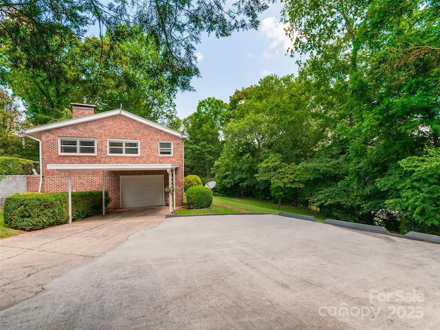 167 Panorama Dr, Franklin, NC 28734 - view of home's exterior featuring a garage, driveway, brick siding, and a chimney