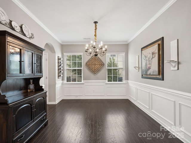 417 Livingston Dr, Lancaster, SC 29720 - unfurnished dining area with a chandelier, arched walkways, a wainscoted wall, ornamental molding, and dark wood-style flooring