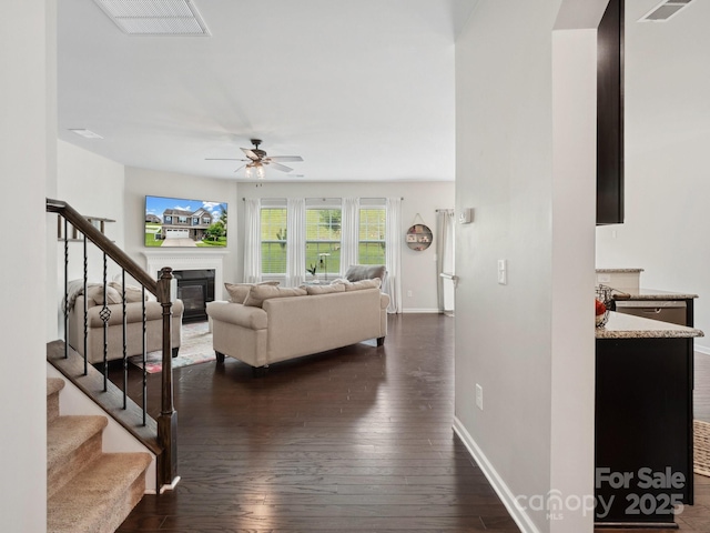 417 Livingston Dr, Lancaster, SC 29720 - living room with stairway, a glass covered fireplace, a ceiling fan, and dark wood-type flooring