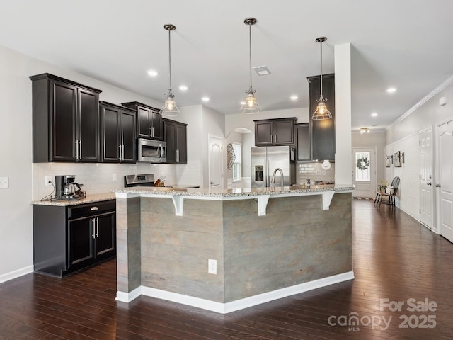 417 Livingston Dr, Lancaster, SC 29720 - kitchen featuring appliances with stainless steel finishes, dark wood-style floors, a kitchen bar, light stone countertops, and recessed lighting