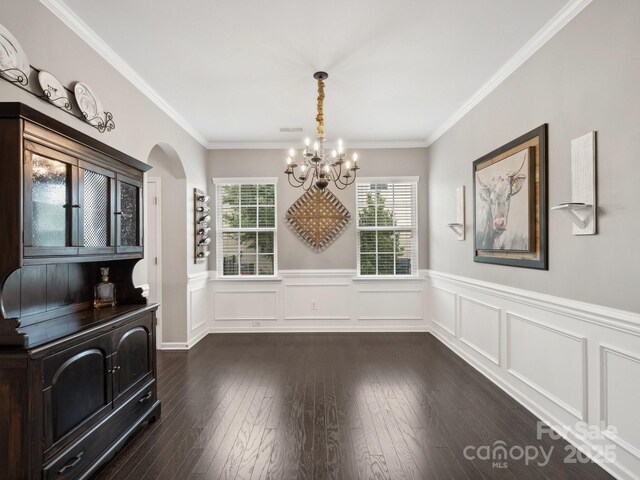 417 Livingston Dr, Lancaster, SC 29720 - unfurnished dining area featuring a chandelier, arched walkways, wainscoting, crown molding, and dark wood-style floors