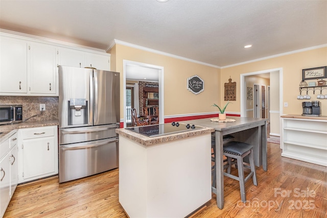 3060 Texs Fish Camp Rd, Connelly Springs, NC 28612 - kitchen with appliances with stainless steel finishes, a kitchen island, ornamental molding, white cabinetry, and light wood-style flooring