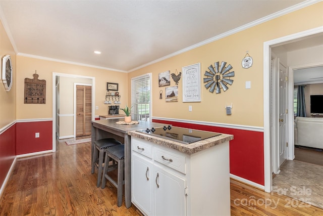 3060 Texs Fish Camp Rd, Connelly Springs, NC 28612 - kitchen featuring black electric stovetop, white cabinetry, light wood-style flooring, ornamental molding, and a kitchen island