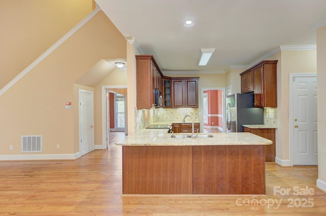 8044 Hawk Crest Ct, Charlotte, NC 28270 - kitchen with appliances with stainless steel finishes, light wood finished floors, a peninsula, glass insert cabinets, and tasteful backsplash