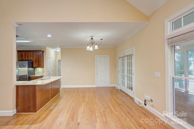 8044 Hawk Crest Ct, Charlotte, NC 28270 - kitchen featuring stainless steel fridge, a chandelier, a peninsula, light wood-style flooring, and ornamental molding