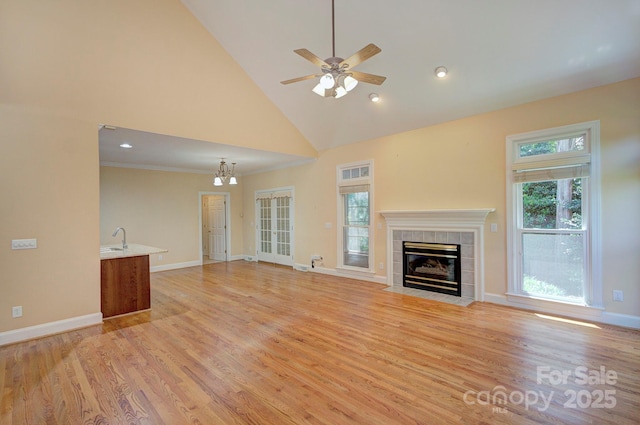 8044 Hawk Crest Ct, Charlotte, NC 28270 - unfurnished living room with a fireplace, high vaulted ceiling, light wood-type flooring, ceiling fan, and a chandelier