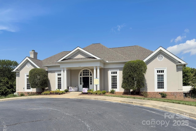 8044 Hawk Crest Ct, Charlotte, NC 28270 - neoclassical home with a chimney, stucco siding, a shingled roof, and brick siding