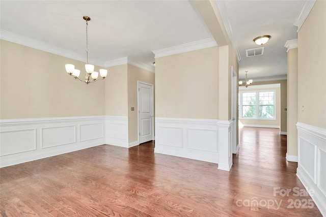 10004 Perth Moor Rd, Charlotte, NC 28278 - unfurnished room featuring a chandelier, a wainscoted wall, crown molding, and wood finished floors