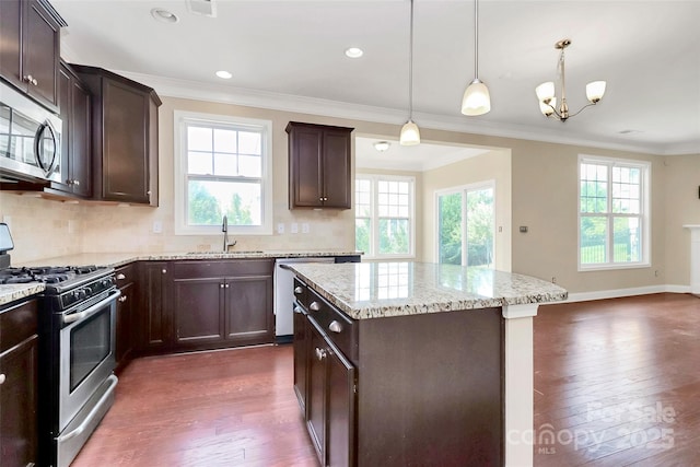 10004 Perth Moor Rd, Charlotte, NC 28278 - kitchen with appliances with stainless steel finishes, a sink, dark wood finished floors, a center island, and crown molding