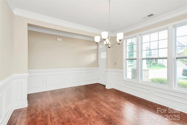 10004 Perth Moor Rd, Charlotte, NC 28278 - spare room with a chandelier, healthy amount of natural light, crown molding, wainscoting, and dark wood-style flooring