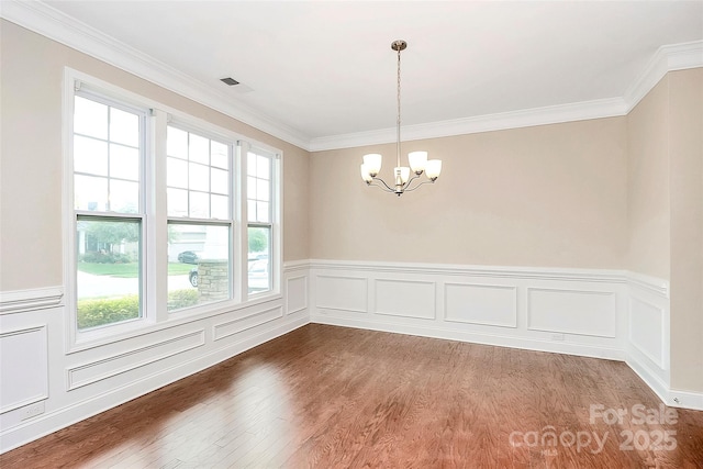 10004 Perth Moor Rd, Charlotte, NC 28278 - unfurnished dining area with healthy amount of natural light, a chandelier, dark wood finished floors, ornamental molding, and wainscoting