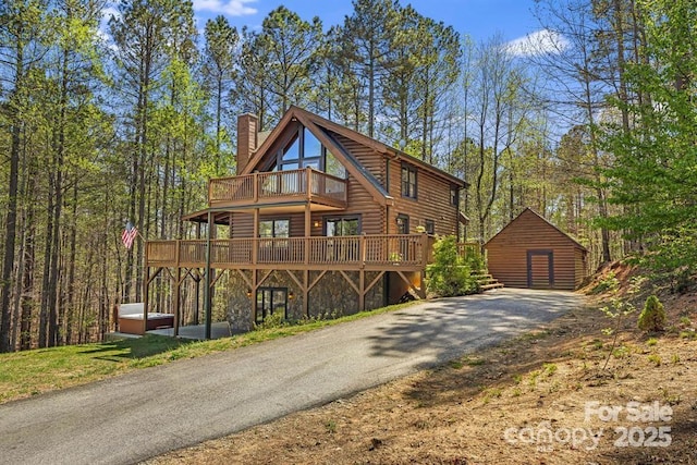 447 Hidden Lake Pkwy, Nebo, NC 28761 - view of front of house with a deck, an outbuilding, a chimney, driveway, and stone siding