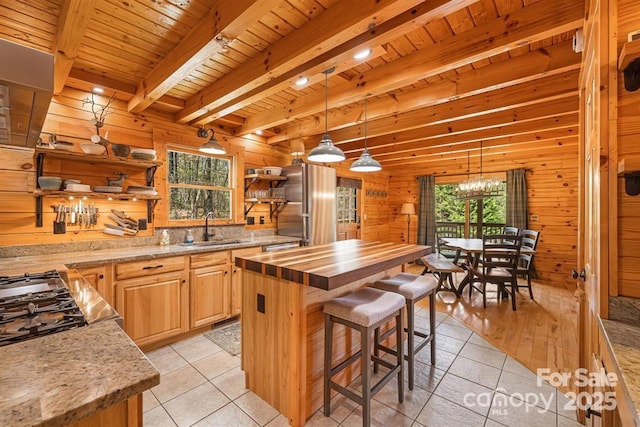 447 Hidden Lake Pkwy, Nebo, NC 28761 - kitchen featuring butcher block counters, a sink, light tile patterned flooring, wooden ceiling with exposed beams, and wooden walls