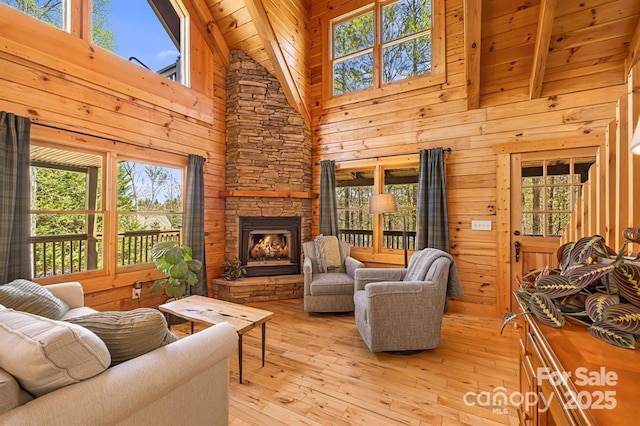 447 Hidden Lake Pkwy, Nebo, NC 28761 - living room with plenty of natural light, wood walls, a stone fireplace, high vaulted ceiling, and wooden ceiling with exposed beams