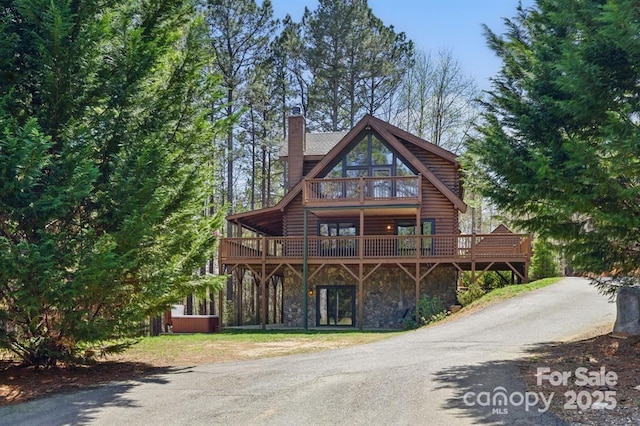 447 Hidden Lake Pkwy, Nebo, NC 28761 - view of front of house featuring stone siding, a wooden deck, a chimney, and log exterior