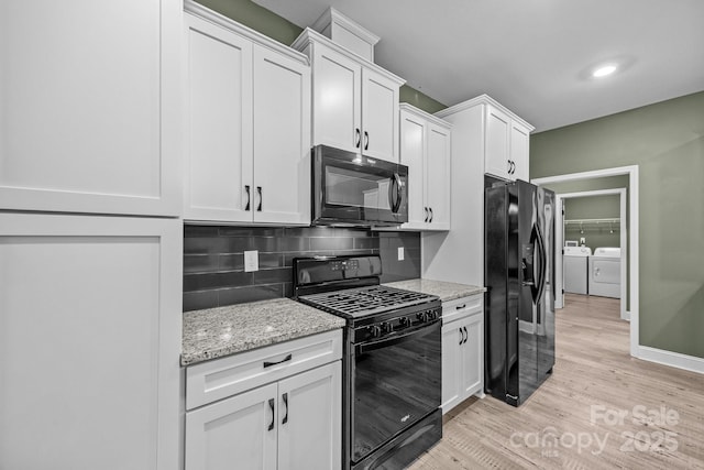 140 Cove Crest Dr, Rutherfordton, NC 28139 - kitchen with black appliances, separate washer and dryer, light wood-style floors, tasteful backsplash, and white cabinetry