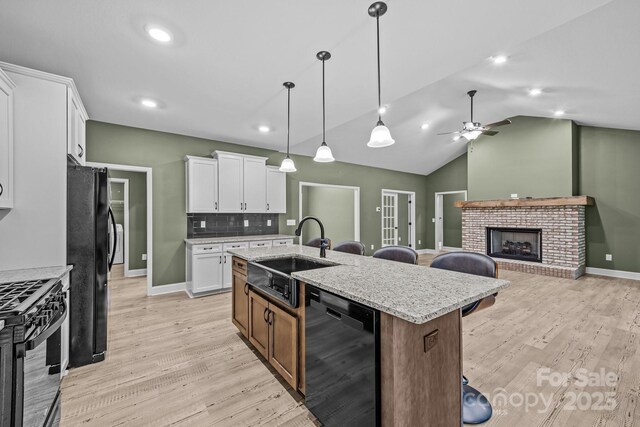 140 Cove Crest Dr, Rutherfordton, NC 28139 - kitchen with black appliances, a sink, a center island with sink, light wood-type flooring, and white cabinets