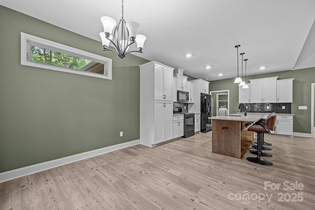 140 Cove Crest Dr, Rutherfordton, NC 28139 - kitchen featuring black appliances, a kitchen breakfast bar, baseboards, white cabinetry, and a sink