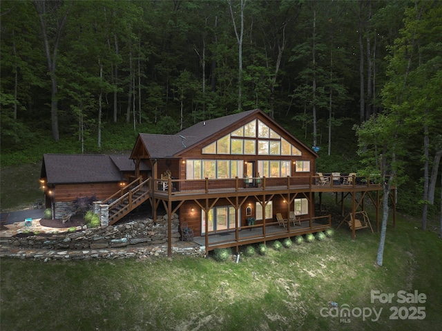 85 Iga Trl, Maggie Valley, NC 28751 - back of house with a wooded view, a deck, stairs, and a yard