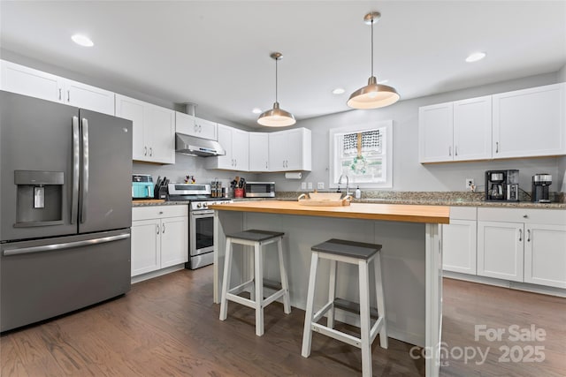 6313 Weddington Rd, Concord, NC 28027 - kitchen with appliances with stainless steel finishes, under cabinet range hood, dark wood finished floors, white cabinets, and recessed lighting
