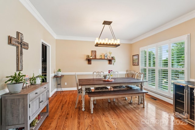 207 Spaniel Dr SE, Concord, NC 28025 - dining space with beverage cooler, crown molding, and light wood finished floors