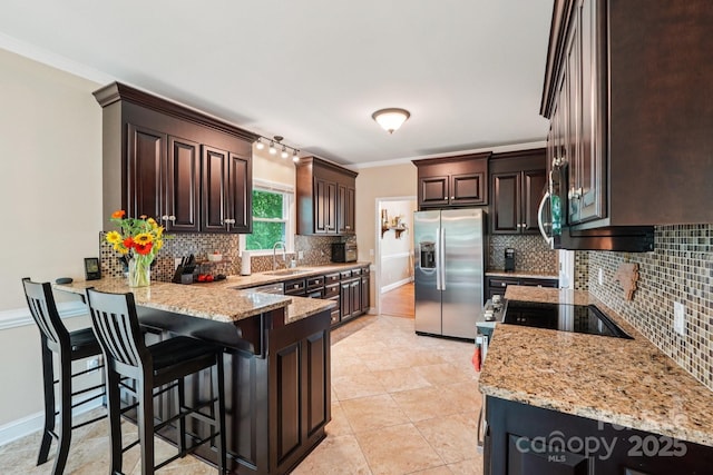 207 Spaniel Dr SE, Concord, NC 28025 - kitchen with appliances with stainless steel finishes, a peninsula, tasteful backsplash, dark brown cabinets, and light stone counters