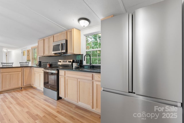 8692 Lambs Way, Connelly Springs, NC 28612 - kitchen with appliances with stainless steel finishes, light brown cabinetry, a sink, and dark countertops