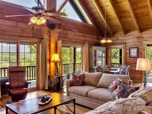 32 Tibi Ln, Waynesville, NC 28785 - living area featuring light wood-style floors, wood walls, a ceiling fan, healthy amount of natural light, and wooden ceiling with exposed beams