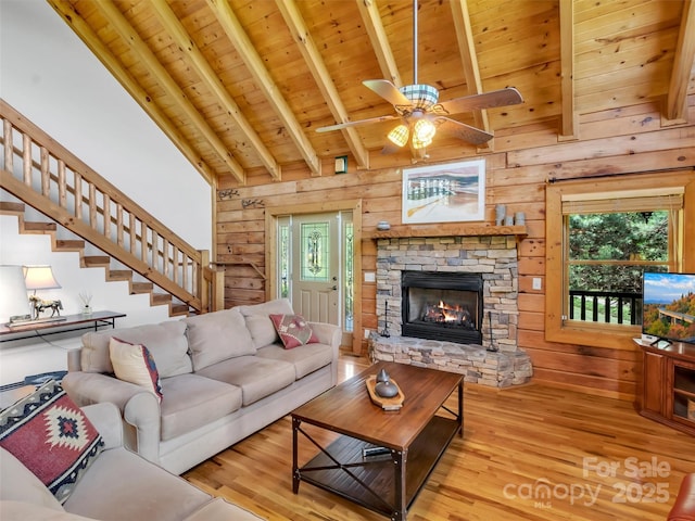 32 Tibi Ln, Waynesville, NC 28785 - living area with wood finished floors, wooden walls, stairway, a stone fireplace, and wood ceiling with exposed beams